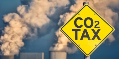 Traffic sign CO2 tax with smoking chimneys in background