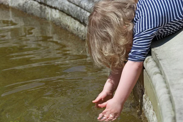 Yürüyen çocuk suya ulaşmaya çalışıyor.