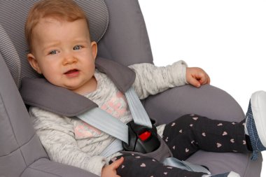 Bebek çocuk koltuğuna bağlı oturuyor.