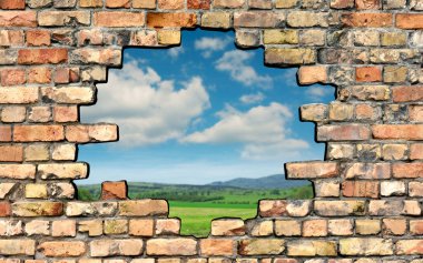 Hole in brick wall with a view of the outside