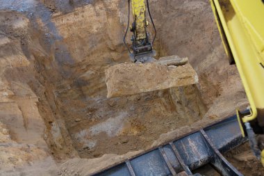 Excavator digs a deep hole for a cistern