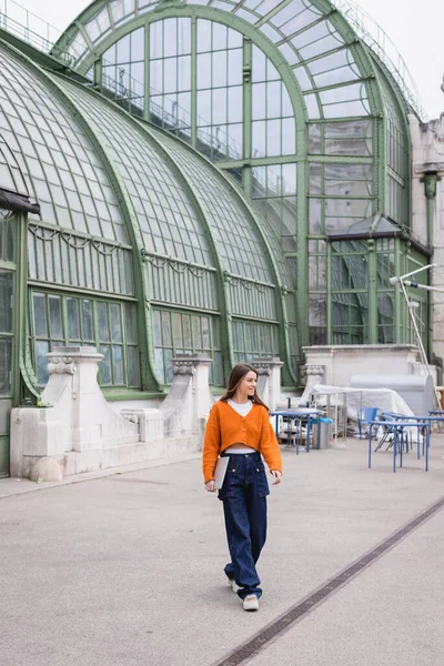 Mujer Joven Feliz Jeans Cárdigan Naranja Caminando Con Ordenador Portátil — Foto de Stock