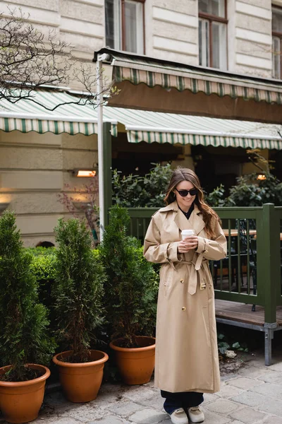 Full Length Happy Young Woman Trendy Sunglasses Trench Coat Holding — ストック写真