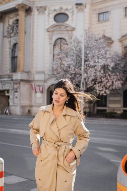 Zarif ceketli kadın Viyana 'nın rüzgarlı caddesinde duruyor. 