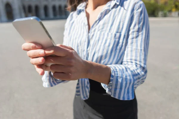 Çizgili Tişörtlü Bir Kadının Cep Telefonuyla Mesajlaşması — Stok fotoğraf