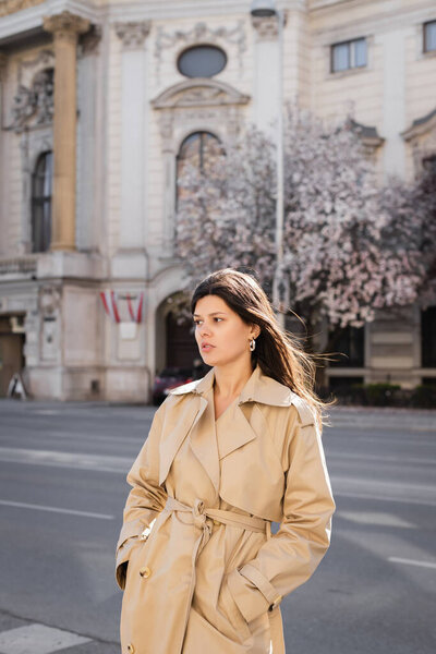 красивая женщина в элегантном пальто, стоящая на улице в Вене 