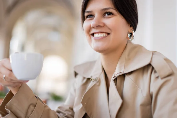 Lycklig Kvinna Håller Kopp Kaffe Och Ler Medan Tittar Bort — Stockfoto