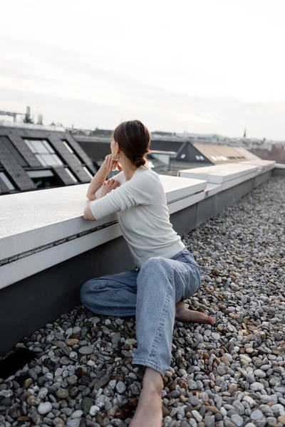 Barefoot Woman Jeans Sitting Rooftop Looking Away — Foto de Stock