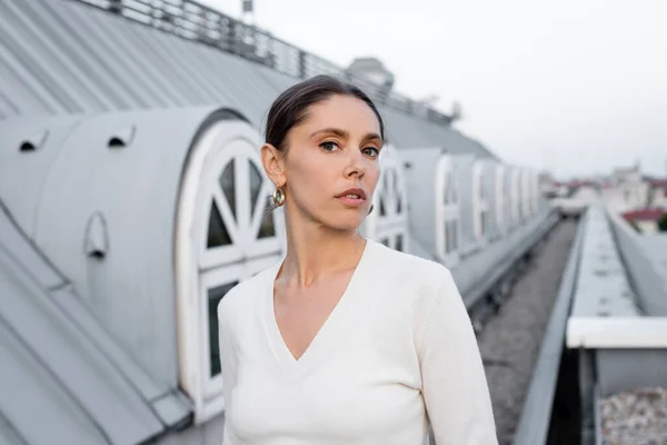 Woman White Jumper Looking Camera Rooftop Blurred Building — Φωτογραφία Αρχείου