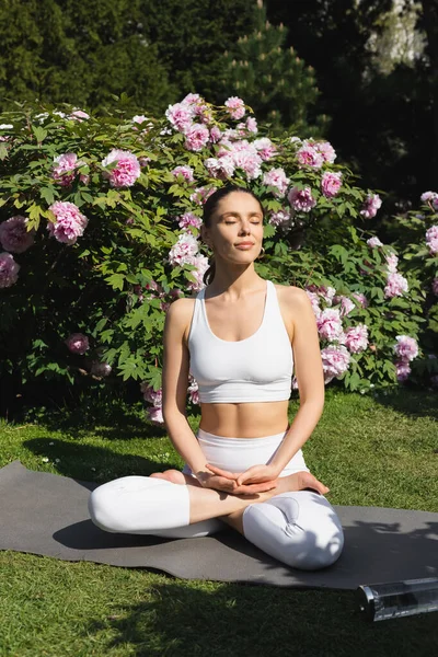 Slender Woman Closed Eyes Sitting Lotus Pose While Meditating Blossoming — Stock Fotó