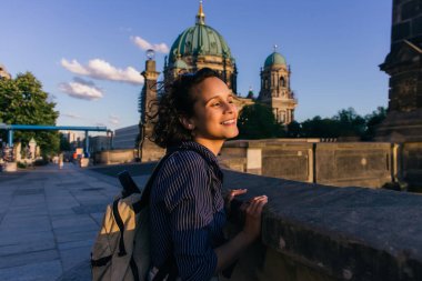 BERLIN, GERMANY - JULY 14, 2020: joyful young woman near blurred berlin cathedral