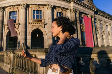 joyful young tourist taking selfie near famous bode museum in berlin 