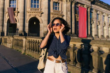 stylish young woman wearing sunglasses near bode museum in berlin  clipart