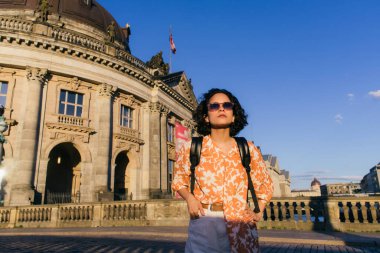 stylish young woman in sunglasses standing near bode museum in berlin 