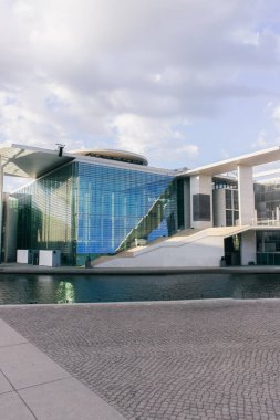 modern contemporary building near pond with clear water in berlin clipart