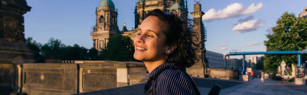 BERLIN, GERMANY - JULY 14, 2020: joyful young woman near blurred berlin cathedral, banner