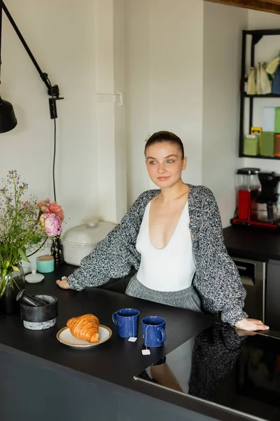Mujer Punto Cárdigan Pie Cerca Croissant Tazas Cocina —  Fotos de Stock