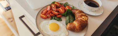 Yumurta ve kahvenin yanında yüksek açılı kruvasan manzarası, pankart. 