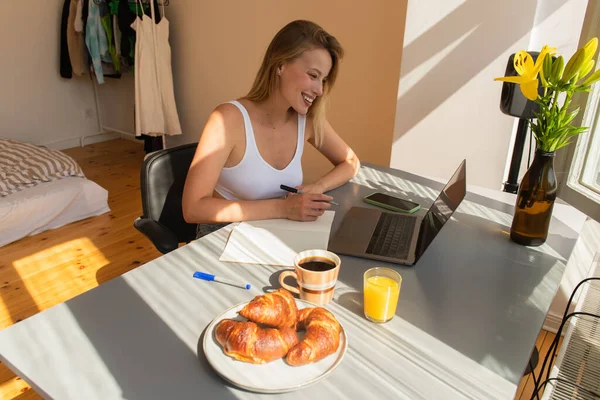 Mujer Sonriente Mirando Computadora Portátil Cerca Del Desayuno Bebidas Casa — Foto de Stock