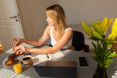 Evdeki masada ayçöreği içki ve aletlerin yanına götüren genç bir kadın. 