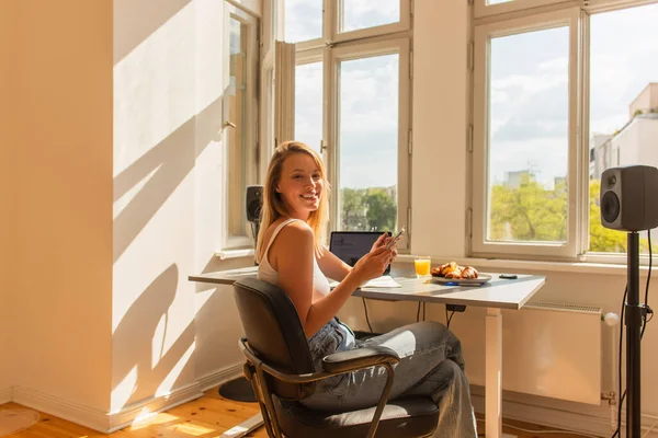 Feliz Rubia Freelancer Utilizando Teléfono Celular Cerca Zumo Naranja Desayuno — Foto de Stock