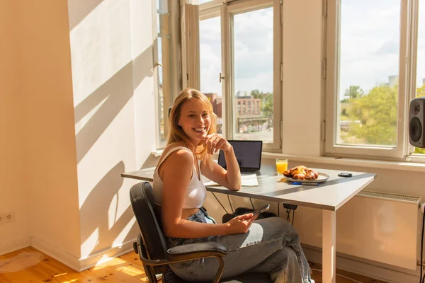 Positivo Freelancer Rubia Mirando Cámara Cerca Los Dispositivos Desayuno Casa — Foto de Stock