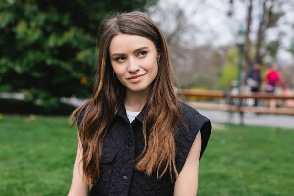 Portrait of young pretty woman looking away in park — Stock Photo