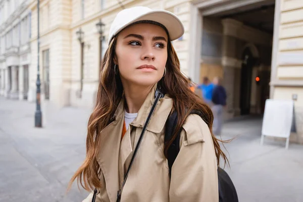 Pretty woman in trench coat and baseball cap — Stock Photo