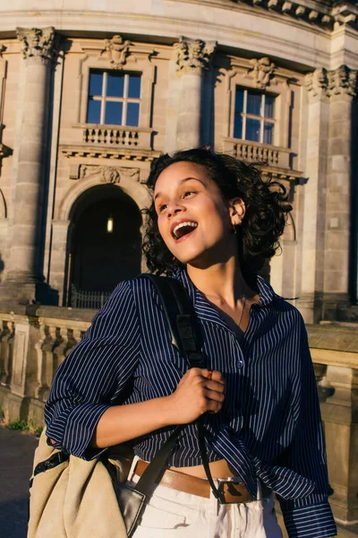 Sunshine on face of amazed young woman with backpack near bode museum on museum island — Photo de stock