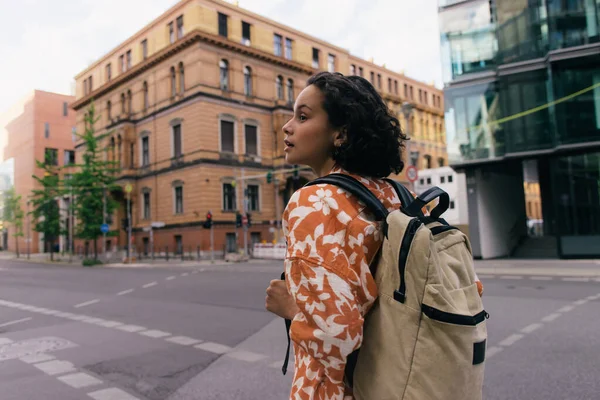 Young woman with backpack standing on urban street in berlin — Photo de stock