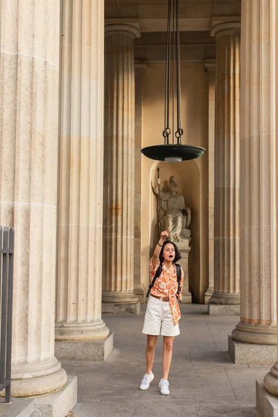 Shocked traveler with backpack standing near ancient columns and statue in berlin — Fotografia de Stock