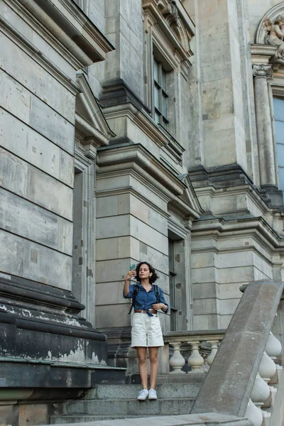 Полная длина туриста делающего селфи на смартфоне перед зданием в Берлине — стоковое фото
