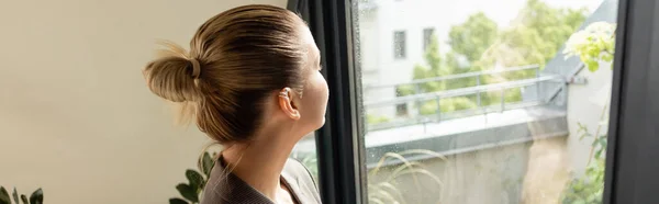 Young woman looking at balcony door at home, banner — Stock Photo