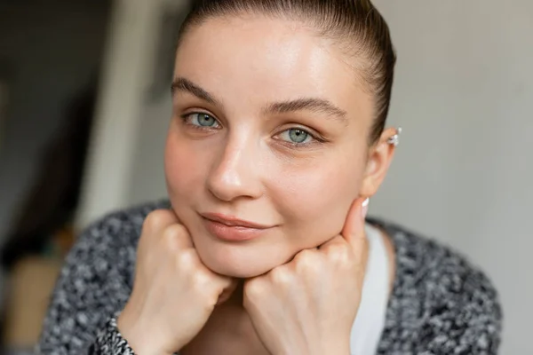 Portrait of woman in knitted cardigan looking at camera at home — Stock Photo