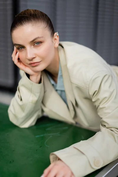 Retrato de una mujer joven con estilo mirando la cámara cerca de la mesa de ping-pong en la calle - foto de stock