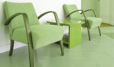 İki zeytin renkli koltuk ve duvarın arkasında yeşil bir sehpa, oturma odasının modern bir iç mekanı ya da otelin salonu..