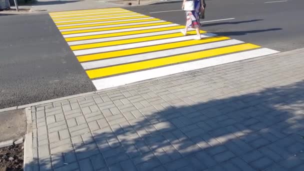 4K视频中 两名行人在过马路时 在一个新的黄白色标志上标注了人行横道 生命安全 交通的概念 — 图库视频影像