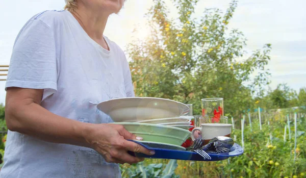 Жінка Тримає Піднос Чистим Посудом Літньому Тлі Дерев — стокове фото