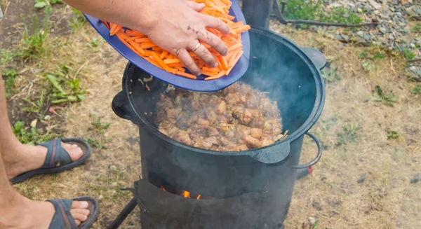 Kaukaski Mężczyzna Gotuje Mięso Marchwi Patelni Wok Otwartym Ogniu Lato — Zdjęcie stockowe