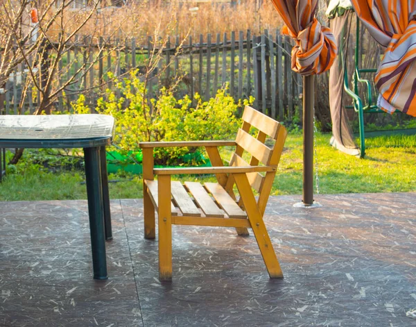 村舍阳台上的木制长椅和塑料绿色桌子 — 图库照片