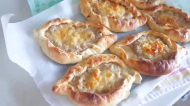 4k video, yavaş kamera hareketi yeni pişmiş ev yapımı et ve peynirli turtalar üzerinde çarşaf havlusu ile parşömen üzerinde uzanan, üst manzara.