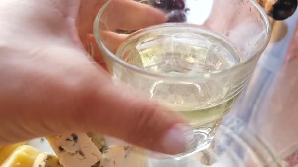 4Kビデオ 女性の手は白い輝くワインのガラスを置き それにチェリーベリーの小枝を掛けます 金型と柔らかいチーズの隣に — ストック動画