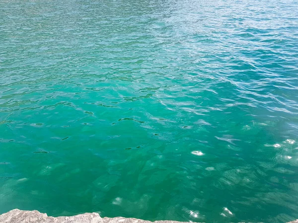 エメラルドグリーンの澄んだ水と陽射しの穏やかな海の背景 — ストック写真