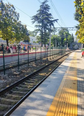 SOCHI, RUSSIA - 11 Haziran 2021: Lastochka treninin Sochi tren istasyonuna varışını bekleyen yolcular, yaz mevsiminde, açık havada.