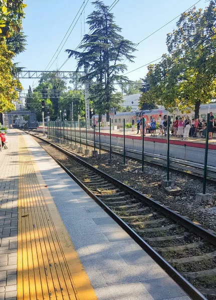 SOCHI, RUSSIA - 11 Haziran 2021: Lastochka treninin Sochi tren istasyonuna varışını bekleyen yolcular, yaz mevsiminde, açık havada.