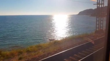 4k video, deniz kıyısı boyunca tren penceresinden bir manzara, gün batımında birinci şahıs tren yolculuğu.