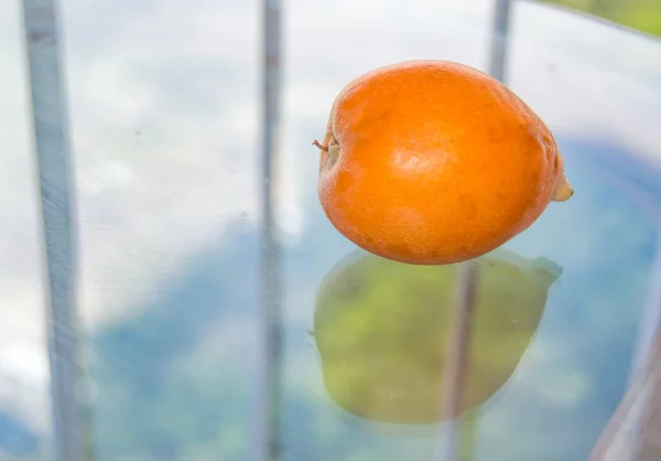 Medlar Ovoce Průhledném Skleněném Stole Balkóně Close Venkovní — Stock fotografie