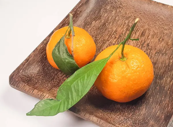 Duas Tangerinas Maduras Frescas Com Folhas Ramos Uma Placa Madeira — Fotografia de Stock