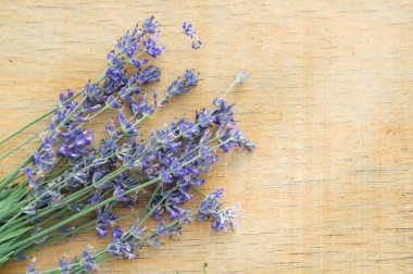 Tahta bir arka planda Provence tarzı lavanta çiçekleri, seçici bir odak.