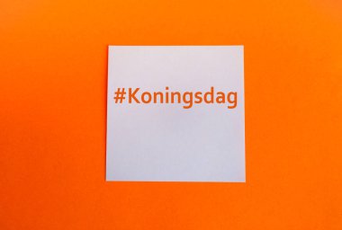Hollanda 'daki Kral Günü kutlamalarının geleneksel renklerinde bir şablon. Turuncu arkaplan ve Koningsdag etiketli beyaz kağıt kare. Boşluğu kopyala.